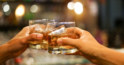 Two men clinking glasses of whiskey 