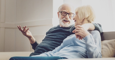 aged woman looking at her beloved man while listening to his jokes
