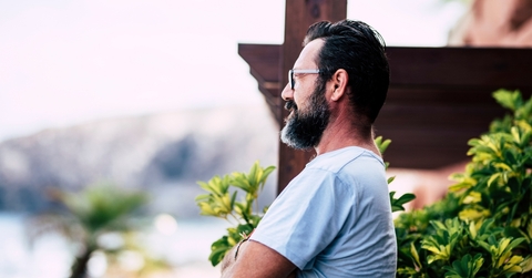 man thinking in front of a house