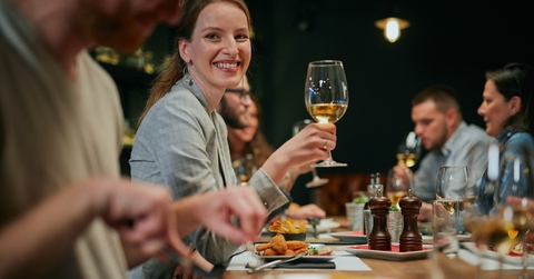 smiling woman sitting in restaurant with friends