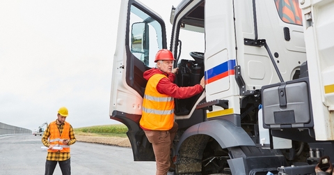 truck driver climbs into his truck with a delivery