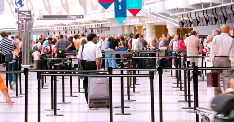 Travelers waiting in an airport security line. 