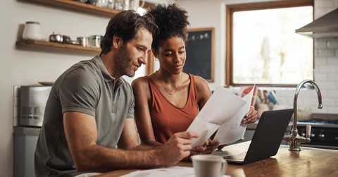  couple using their laptop and going through paperwork