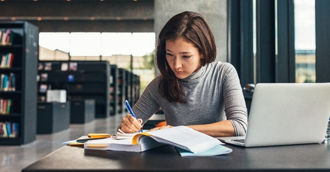 female student studying at college library