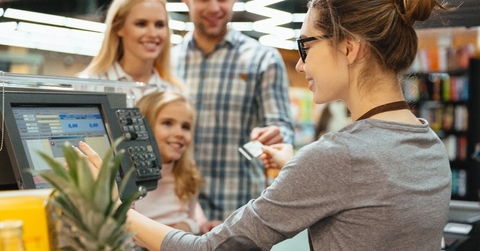 smiling family paying for their groceries