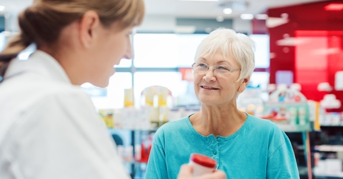 senior woman in pharmacy talking to the pharmacist
