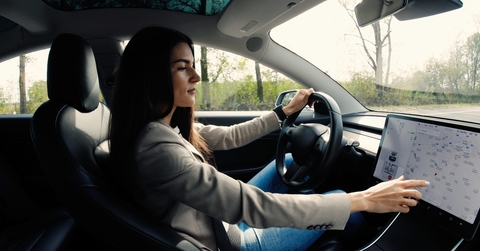 woman sitting in electric vehicle Tesla Model 3