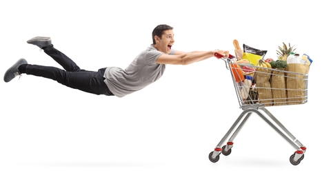 man being pulled by a shopping cart full of groceries