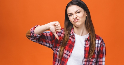 young woman wearing red flannel shirt doing thumbs down