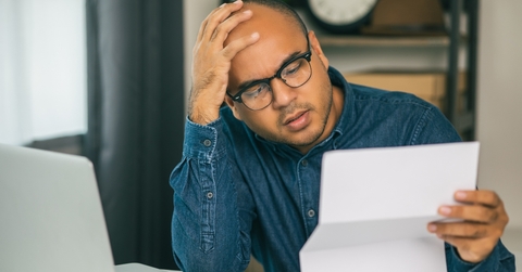 man is stressed because he looks at many expense bills