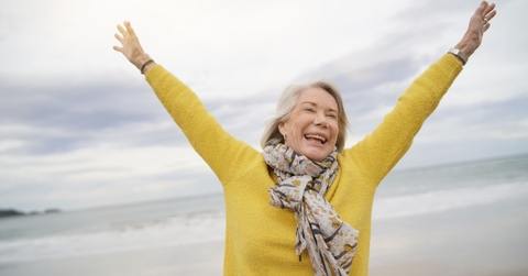 happy senior woman holding hands in air outdoor