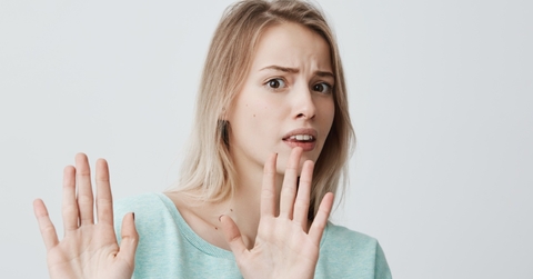 woman in blue sweater saying no using hand gestures