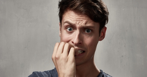 young man biting his nails in exhaustion