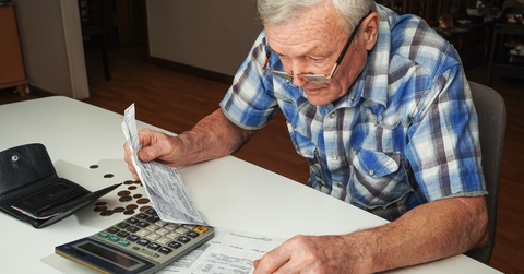 senior man sitting at the table and calculating finances