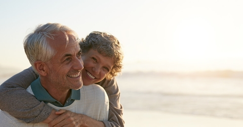happy senior couple having each other back and enjoying at beach