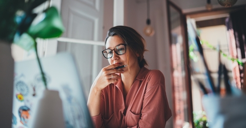 businesswoman thinking about something while sitting infront of laptop
