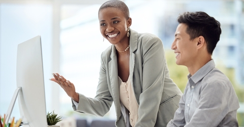 woman training a male employee in the office