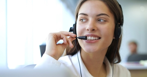 beautiful woman at workplace talking to customer on headset