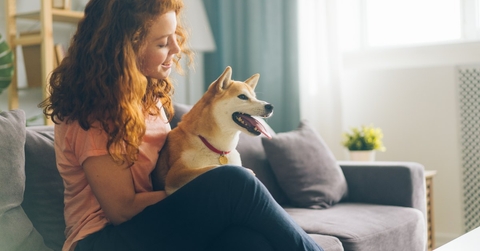 A happy woman with a dog she's pet sitting while house sitting