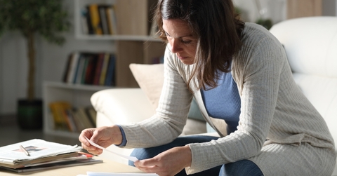 woman checking receipts at home at night