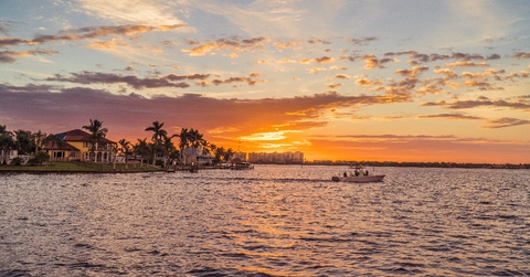 cape coral waterfront with boat and palm trees 