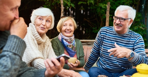 cheerful seniors enjoying time together drinking tea