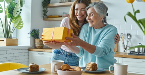 surprised senior mother receiving a gift box from her daughter
