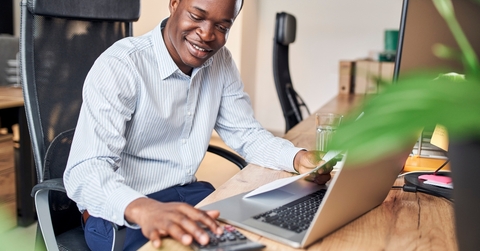 young businessman calculating business income