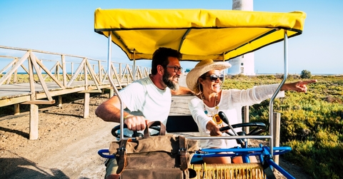 happy adult couple on a surrey bike enjoying the outdoor