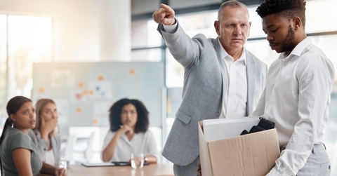 man fired by boss in a meeting holding a box in disappointment