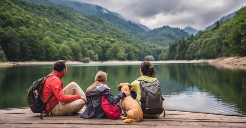 family having a vacation with their dog at mountainous area resting on pier together