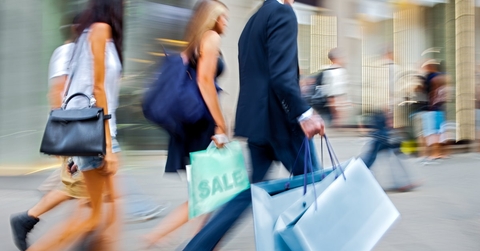 people walking around the shopping street holding shopping bags