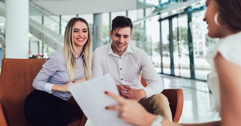financial advisor showing report to young couple