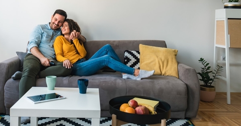 couple relaxing together on -their sofa at living room