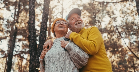 middle age cheerful people smiling and looking at the the trees 