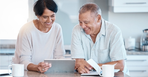 happy asian couple using tablet on countertop 
