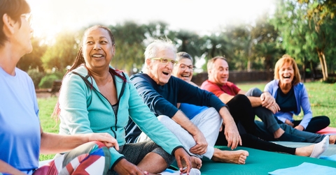 multi-ethnic seniors doing yoga in park