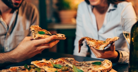 couple sitting at restaurent eating pizza 