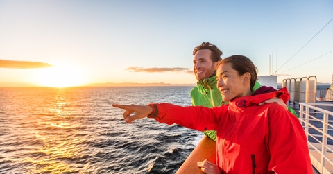 cruise travel tourists couple pointing at sea view from ferry tour
