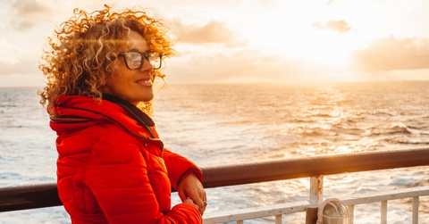 young adult woman enjoying sunset  on a ferry cruise