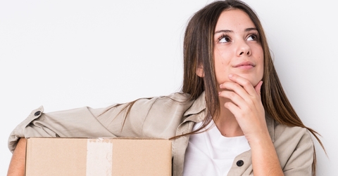 woman thinking while holding moving boxes