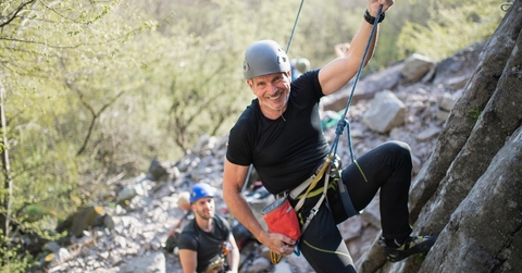 Men rock climbing smiling