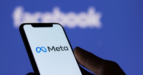 man holding smartphone with meta logo