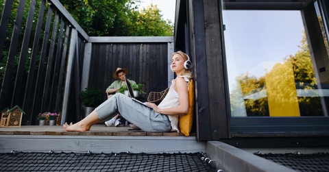 young couple with laptop resting outdoors in a tiny house