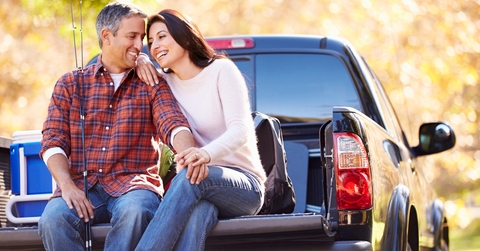 couple sitting in pick up truck on camping holiday