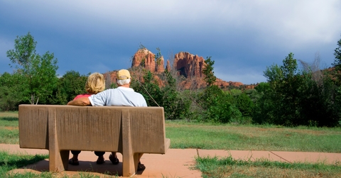 senior couple enjoying vacation while sitting on bench in arizona during day time