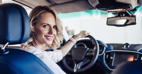 smiling woman sitting in the car