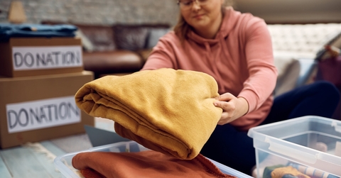 woman sorting out clothes in donation box for charity