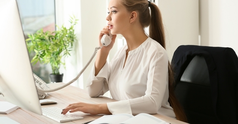 female secretary talking on telephone in office