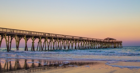 myrtle beach ocean pier with coastal tides at sunset 